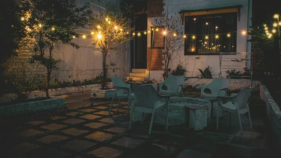 People relaxing on a contemporary patio with warm lighting during evening