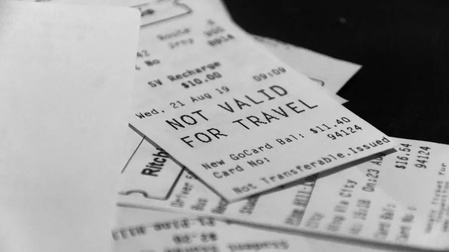 Person comparing prices on receipts while shopping, holding documents at checkout counter